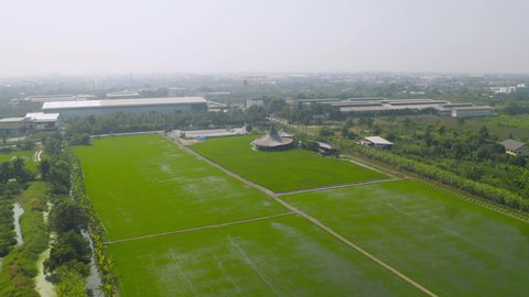 Aerial view of Chata Thammachart, a coffee shop in Sam Phran, Nakhon Pathom Province, Thailand. Asian paddy rice in green agricultural fields in countryside or rural area in Asia. Nature landscape