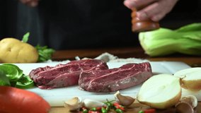 man hand putting ingredient onto beef steak for cooking