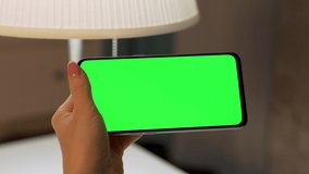 Female Finger Hand Touching Center of Green Screen of Horizontally Phone, Green Background, Chroma Key, Blank, Close-up. Woman Uses Smartphone, Internet, Video Calling, Social Networks, Watches Video.