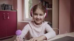 Distance Learning Schoolgirl Studying Online Using Laptop Making Thumbs up. School Student in Headphones Approved Distance Learning Showing Thumbs up. Caucasian Girl Wear Headphones Learn Online Class