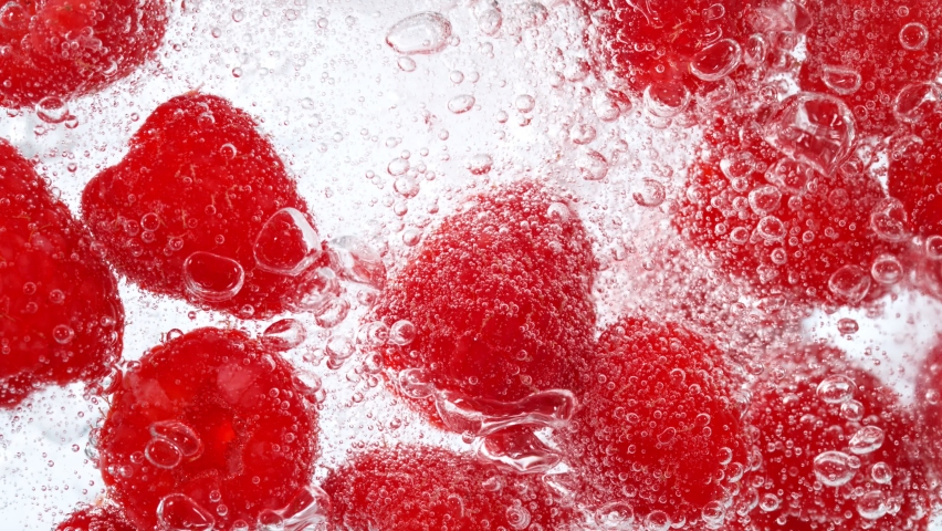 Super Slow Motion Shot of Fresh Raspberries with Sparkling Water and Ice Cubes, Home Made Lemonade. Filmed on high speed cinema camera at 1000fps.