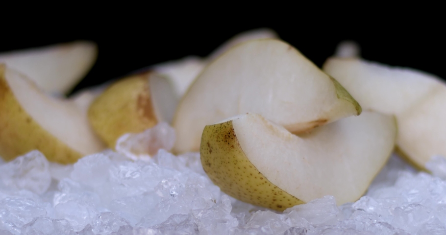 Slow motion of ice cubs filling in sliced pears, fresh fruits for juicy, cold, white food for summer time. Filmed on high speed cinema camera, 8K downscale, 4K.