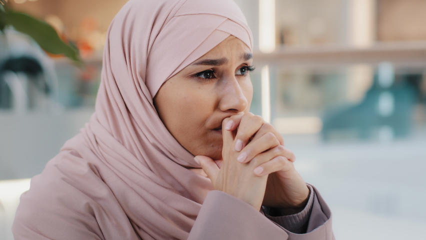 Close-up upset young woman gets bad news feels stressful anxiety frustrated muslim girl suffers from headache grabs head with hands migraine unresolved problems feeling sorrow grief divorce job loss | Shutterstock HD Video #1084871485