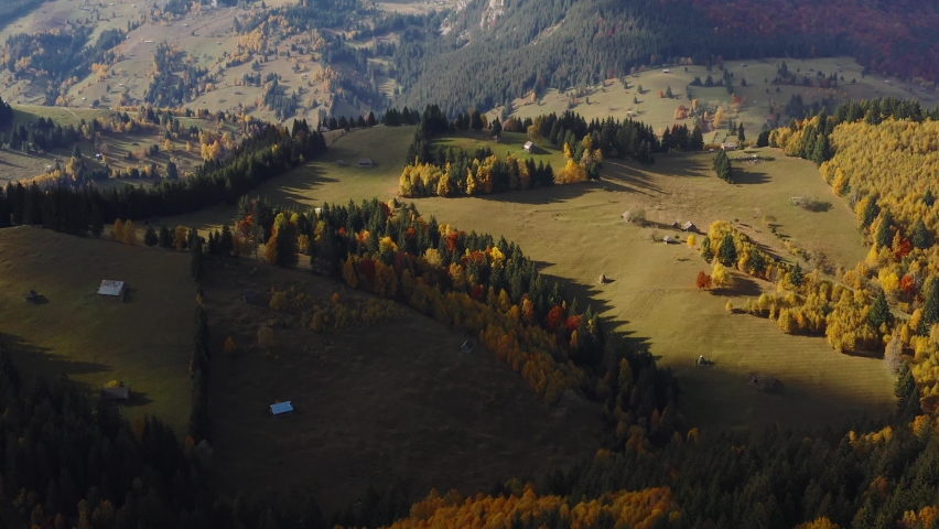 Travel to Romania. 4K aerial video with the beautiful traditional landscape of the villages from Rucar Bran pass in autumn color forests. Visit Transylvania.