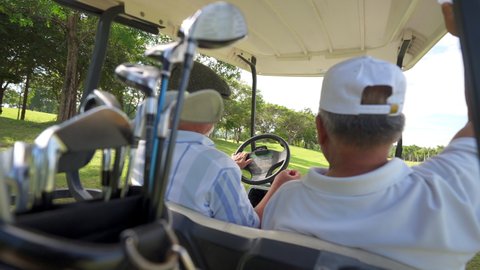 Group of Asian people businessman and senior CEO enjoy outdoor activity lifestyle sport golfing together at golf country club. Healthy men golfer driving golf cart on golf course in summer sunny day