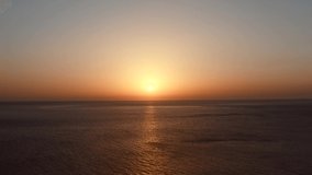 Calm ocean, small ripple motion at sunset. Aerial still video.  Sun falling over Agean sea, orange color sky, reflection on water surface