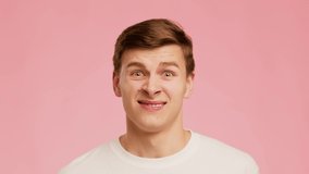 Disgusted Millennial Guy Frowning And Grimacing Looking At Camera Posing And Expressing Negative Emotions Disapproving Something Standing Over Pink Background. Studio Shot