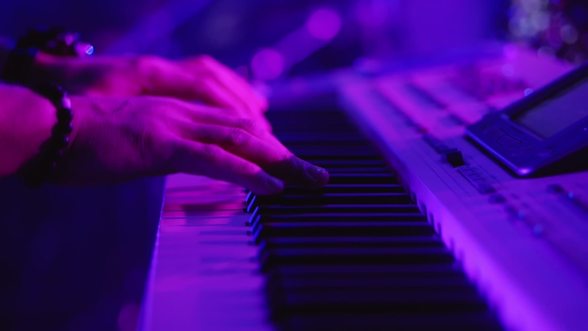 Male hands playing on synthesizer piano. Band at concert stage playing music. Royalty-Free Stock Footage #1084877149