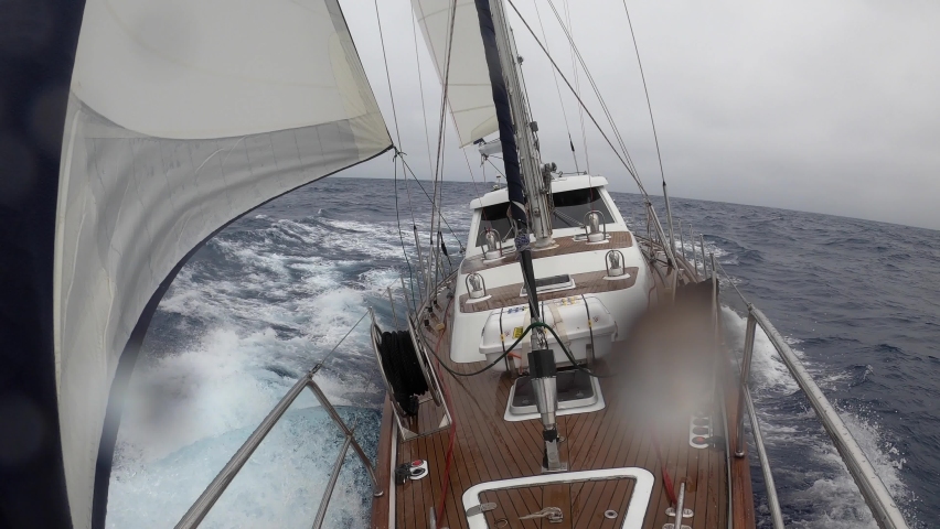 Storm in the Drake Passage on a sailing yacht trip to Antarctica. The view from the the bow of the yacht to the captain's cabin against the backdrop of large ocean waves. Adventure travel lifestyle. Royalty-Free Stock Footage #1084879147