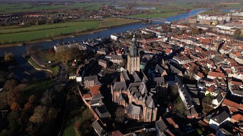 Overview aerial of Walburgiskerk church in the middle of picturesque tower town of Zutphen in The Netherlands with river IJssel passing by the medieval Hanseatic city center
