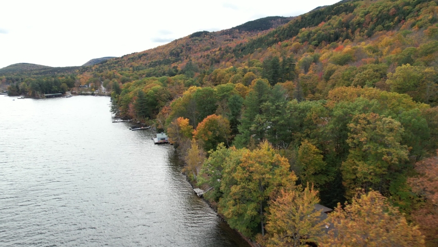 Aerial View of Scenic Lake Sunapee Coast, Colorful Fall Landscape, Forest Houses on Lakefront and Countryside Road, New Hampshire USA, Drone Shot