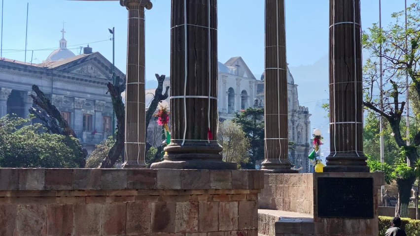 Neoclassical Columns Structure With Church In The Background In Central American Guatemalan City Center Park. Parque Central Quetzaltenango Xela Guatemala. Royalty-Free Stock Footage #1084882084