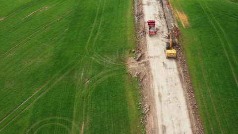 Tatra red truck transports soil from the field along a dirt road, October 2021, Prague, Czech Republic.