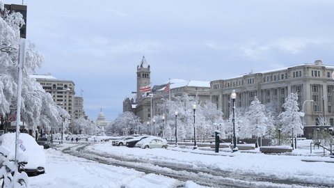 Washington, DC - USA - January 3 2022: Snow covered Pennsylvania Avenue following a major winter storm. The U.S. Capitol Building, Freedom Plaza, the Wilson Building, and Old Post Office are seen.
