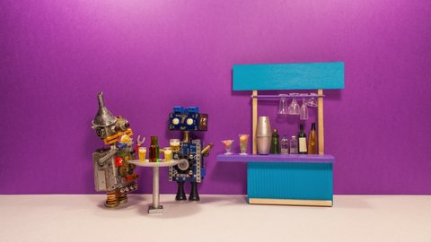 Two funny friendly robots drink beer. The concept of a beer party or meeting of friends in a bar, pub or restaurant. Stop motion animation