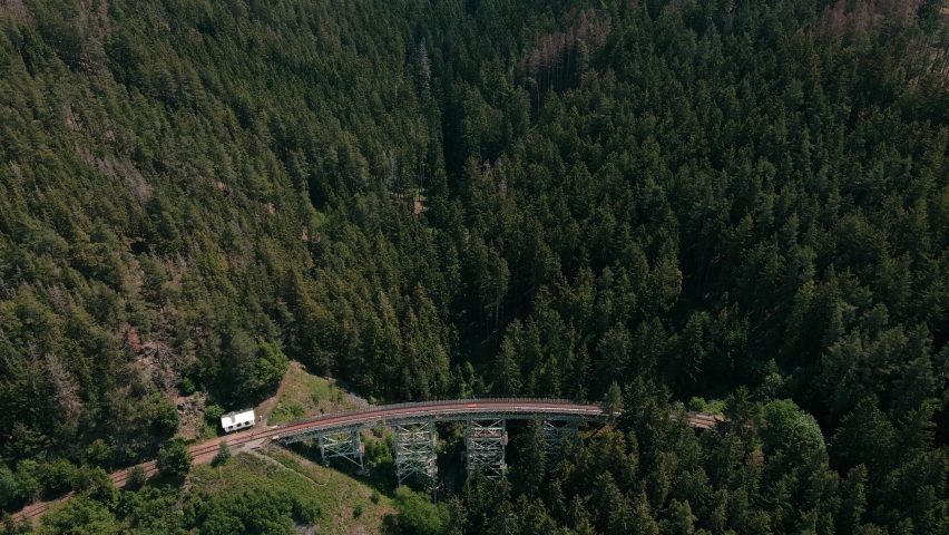 Drone 4k shot of an old train bridge in the middle of green forest. 