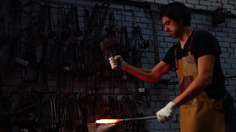authentic italian brunette man blacksmith working in the workshop