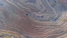 Open pit mining for steel production. A giant iron ore quarry. Aerial view of an open pit. Extraction of ore from the bowels of the earth. Environmental damage to industry. Drone video