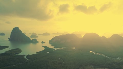 Phang Nga national park in Thailand, dramatic epic sunset behind rock islands in bay, mangrove forest and rivers. Rocks sticking out of the water. Aerial view from above