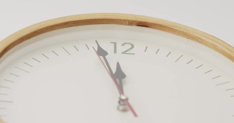 White wall clock tells the time 12 o'clock. It's time to take a break and eat.