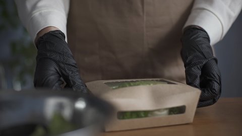 Food delivery services. Restaurant worker collecting a food box take away