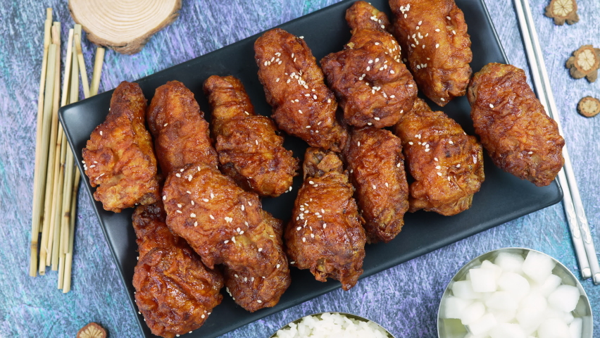 Traditional Korean food, Korean Fried chicken with spicy sauce  with rice, seaweed and Kimchi pickle on wooden table. Royalty-Free Stock Footage #1084902052