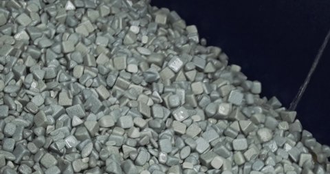 Industrial tumbling. Abrasive stones for vibration grinding metalwork production. Different shapes of machinery material for metal grinder. Heavy machine equipment wet pebble with water stream closeup