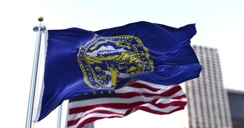 the flag of the US state of Nebraska waving in the wind with the American flag blurred in the background. Nebraska was admitted to the Union on March 1, 1867 as 37th state