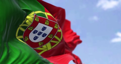 Detail of the national flag of Portugal waving in the wind on a clear day. Democracy and politics. European country. Selective focus. Seamless Slow motion
