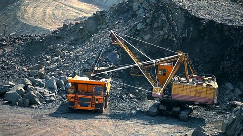 An excavator in a quarry loads soil into a dump truck. The concept of the work of a dump truck in the extraction of iron ore. Modern ex-author with graphic elements