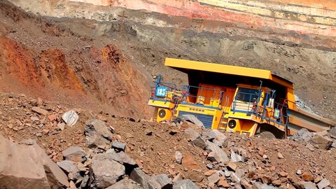Large mining dump truck. Large dump truck in a coal mine. Yellow dump truck in a coal mine. The dump truck drives through the quarry.