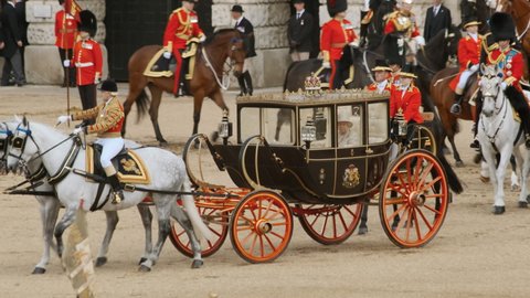 LONDON, circa 2019 - Queen Elizabeth II of England travels in the Scottish State Coach followed by Prince Charles, Princess Anne, Prince Andrew and Prince William on horseback in London, England, UK