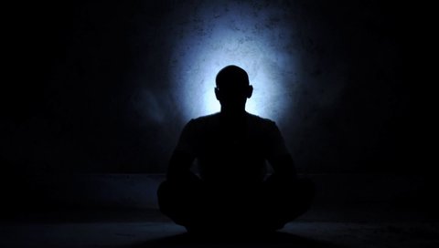 Shining particles on the background of a meditating person