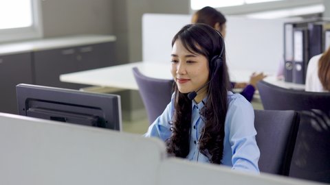 Attractive business Asian woman in headsets working with desktop computer at home office. telemarketing customer service agents