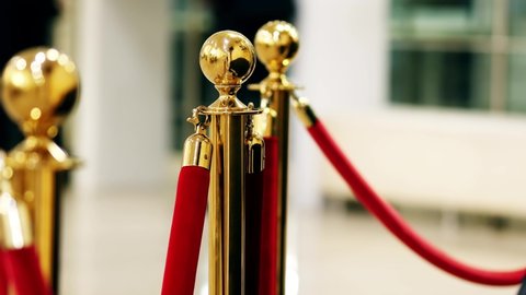 Velvet red luxury ropes closed at valuable exhibit in museum or vip zone concert or performance. Gold plated racks with polished balls. Interior barrier for presentation, show, exhibition or display
