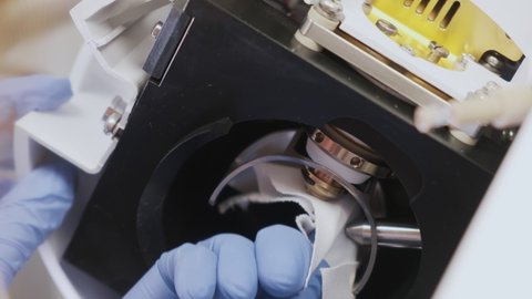 Close up scientist cleaning an ion source of mass spectrometer with lint free cloth and solvent. Maintenance or cleaning of LC Ms qTOF system. Routine in the analytical laboratory.