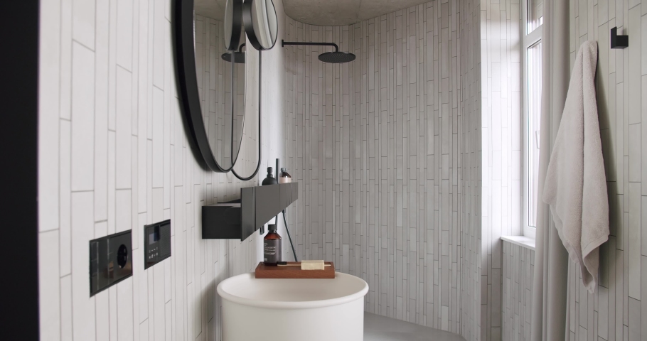 Luxury Bathroom Interior, minimalist interior in white colors with bathroom accessories , mirror and shower head, round mirror in modern interior | Shutterstock HD Video #1084930312