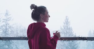 Woman drinks tea, and relax on terrace at home in winter day. Health care, authenticity, sense of balance and calmness. Fresh air, It's Snow time. 4K Video