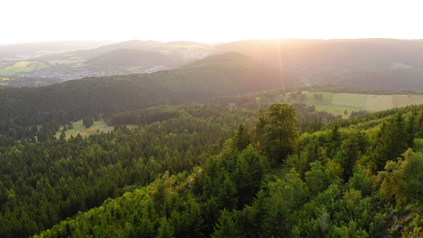 Aerial Forward Shot Of Man Standing On Hilltop Amidst Forest - Thuringia, Germany Royalty-Free Stock Footage #1084937368