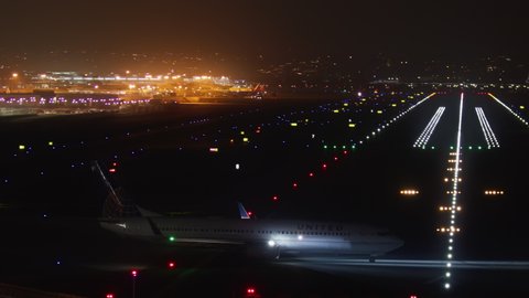 San Diego International Airport, 2021. Big passenger aircraft preparing to depart from illuminated runway. Plane with additional lighting ready to take off over the night city. High quality 4k footage