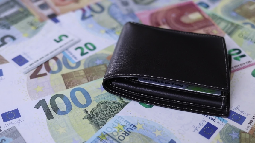 black wallet is on euro banknotes	