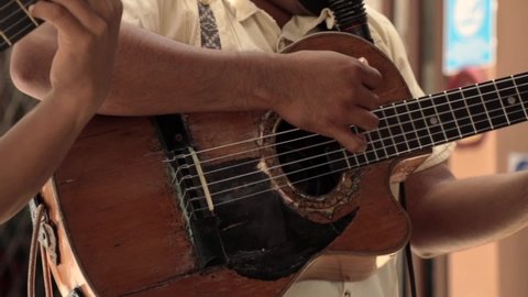 Hispanic Male Playing Old Guitar, Showing Arms Only