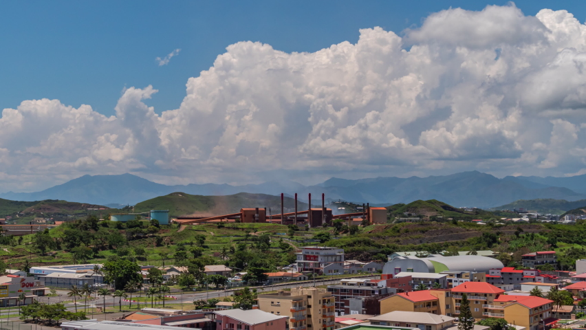 View of a suburb of Noumea, New Caledonia featuring the nickel extraction factory or SNL Société le Nickel - wide angle time lapse