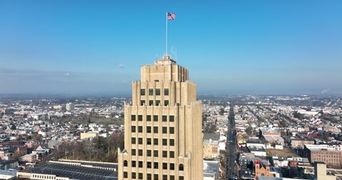 Aerial orbit of American Flag on PPL Headquarters building in Allentown Pennsylvania. Lehigh Valley metropolitan urban city in PA, USA.