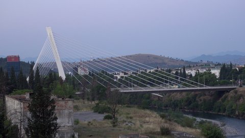 PODGORICA, MONTENEGRO - SEPTEMBER 15, 2021: Blue hour morning view on Millennium Bridge and Moraca river in Podgorica, Montenegro. Editorial, 4K. Contains binaural audio. Medium shot