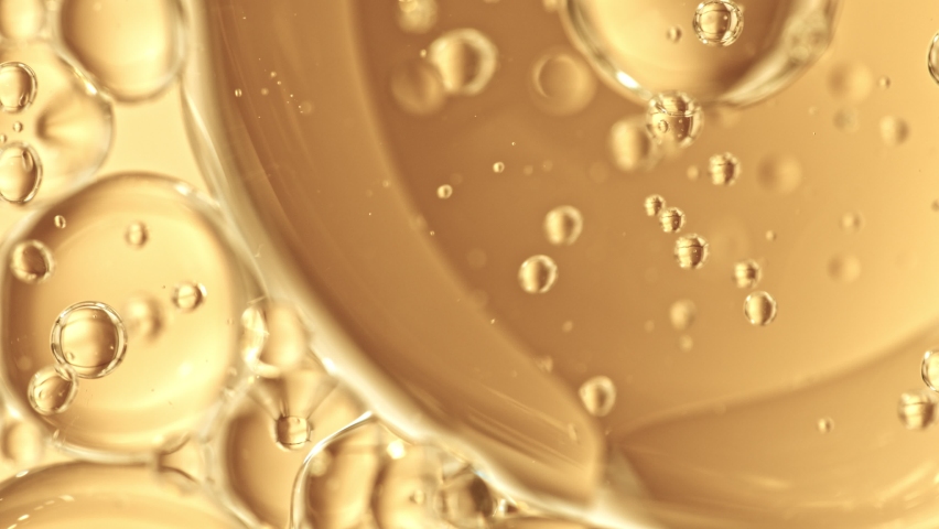 Super Slow Motion Shot of Moving Oil Bubbles on Golden Background at 1000fps. Royalty-Free Stock Footage #1084955212
