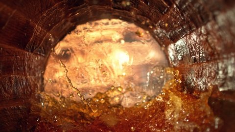 Super Slow Motion Shot of Splashing Whiskey in Old Oak Barrel at 1000fps.