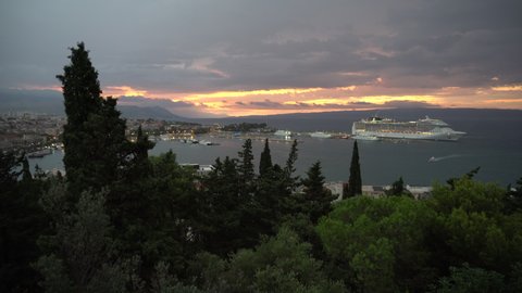 SPLIT, CROATIA - AUGUST 27, 2021: Large cruise ship and small boat at the sunrise in Split, Croatia. 4K, Audio. Wide shot