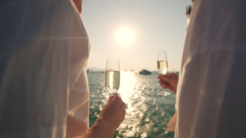 4K Group of man and woman friends enjoy party drinking champagne together while catamaran boat sailing at summer sunset. Male and female relax outdoor lifestyle on sail yacht tropical travel vacation Royalty-Free Stock Footage #1084957465