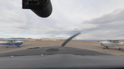 Cessna 182 airplane taxiing down Colorado's Rocky Mountain Metropolitan Airport towards runway in Denver